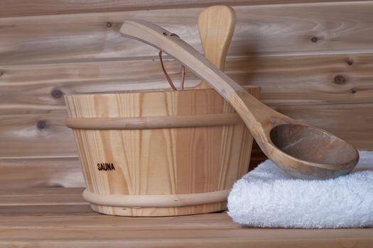 bucket with ladle on top of towel in a wood sauna cabin