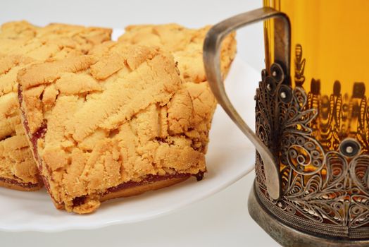 Tea in a glass in the cup holder and saucer with cookies.