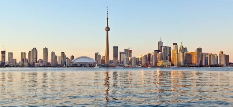 The landmark Toronto downtown view from the center island. Scenic view of the Tower illuminated by the iconic downtown skyline of skyscrapers and high rise condominiums reflecting in Lake Ontario 