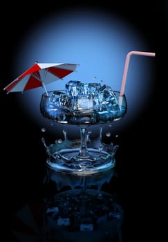 cool refreshing cocktail with ice cubes, umbrella and straw in a long-stemmed glass on a dark background with blue light