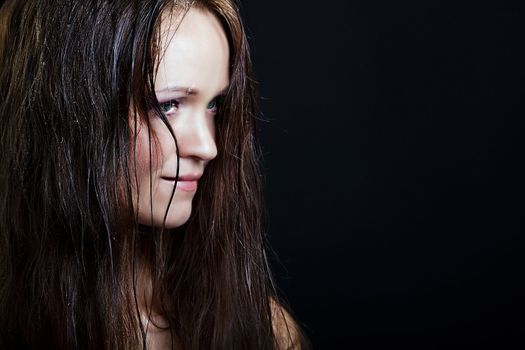 beautiful girl with long wet hair on a black background