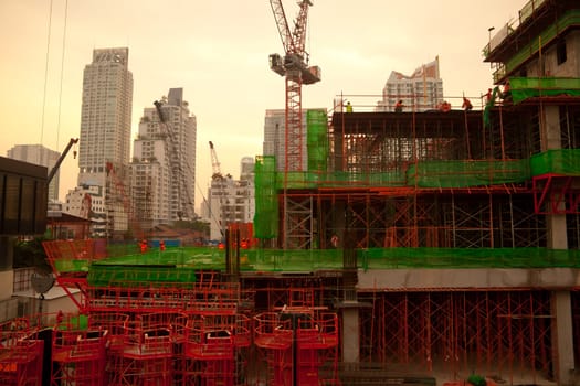 Industrial construction cranes and building at twilight