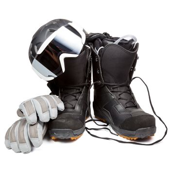 Snowboard boots with helmet gloves and goggles on white background