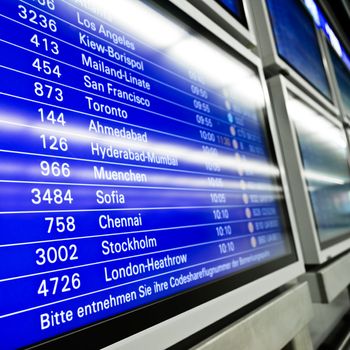Blue flight information board in airport, selective focus