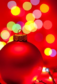 Red Christmas bauble with blured lights in background, very shallow DOF