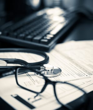 Stethoscope on a prescription form with glasses pen and keyboard, very shallow DOF