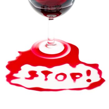 The word Stop written with poured red wine