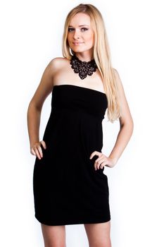 Young and beautiful woman with blond hair in a black cocktail dress on a white background isolated