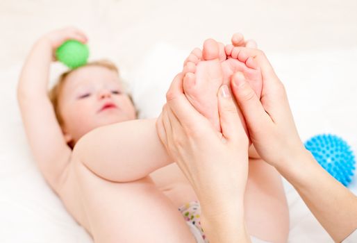 Masseur massaging child's feet, shallow focus