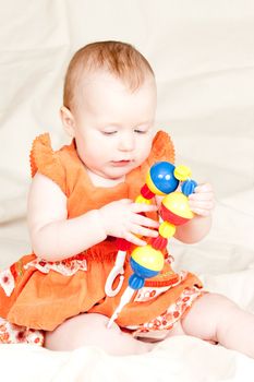 Little baby girl playing with rattle