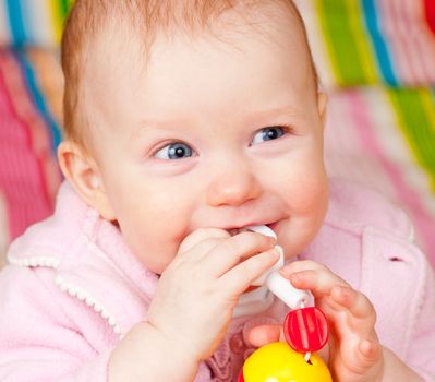 Cute little baby girl playing with teething toy
