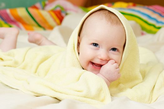 Happy four month baby girl in towel