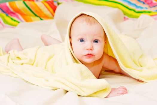Cute little baby girl in yellow towel