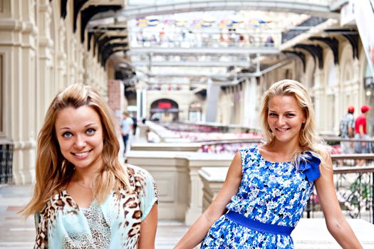 Two young beautiful woman in a shopping center