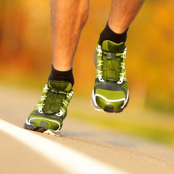 Running shoes on runner jogging outside. Closeup of running shoes in action outside.