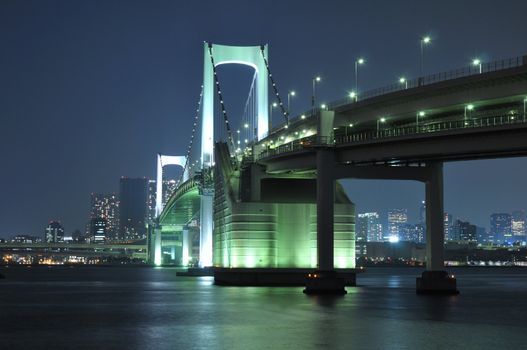 one of famous Tokyo landmarks, Tokyo Rainbow bridge over bay waters with scenic night illumination