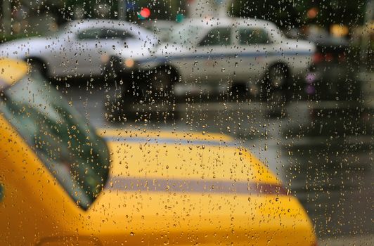 taxi parking lot taken through rainy drops on window; focus on water drops