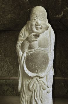 Sculpture of Japanese god Hotei at Jochiji Temple in Kamakura. Hotei is one of Japan's Seven Lucky Gods also known as God of contentment and happiness.