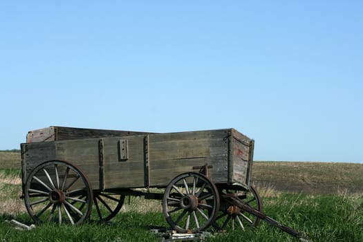 An abandoned antique wagon in a farmers field in spring in Morden, Manitoba, Canada