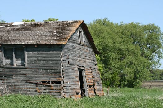 An old barn in an abandoned farmyard collapsing in spring in Morden, Manitoba, Canada