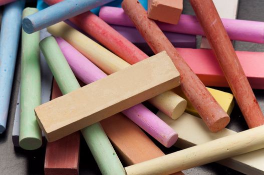 Close-up of colorful large chalk sticks on blackboard