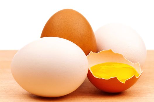 Fresh chicken eggs on wooden board over white background