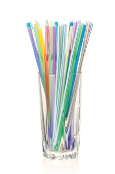 Colorful cocktail straws in glass on a white background