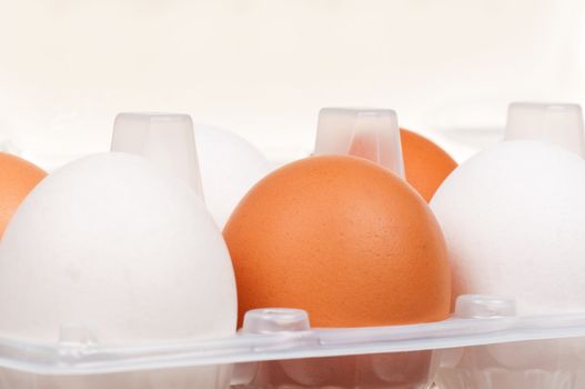 Close-up of brown and white eggs in the plastic box