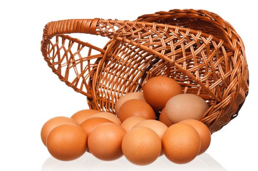 Brown eggs in the wicker basket over white background