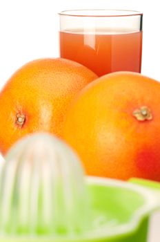 Glass of fresh grapefruit juice, juicer and grapefruit fruits on white background