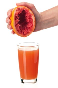 Glass of fresh grapefruit juice and hand with half of grapefruit on white background