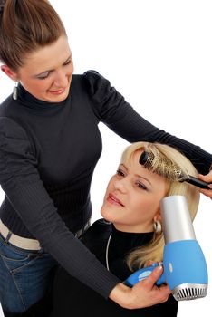 Two girls in hair-dress salon drying hair