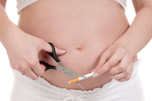 Pregnant belly with cigarettes - isolated over a white background. Third trimester.