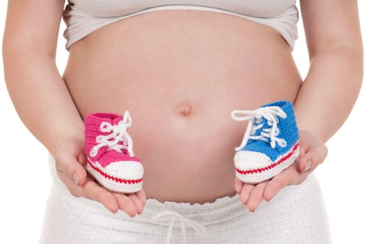 Pregnant woman holding a baby's bootees in different colours