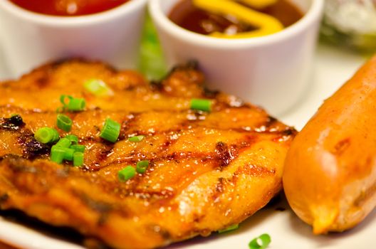 Closeup of Chicken Teriyaki steak and veal sausage.