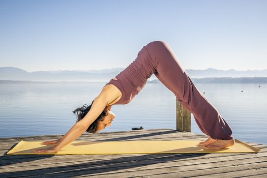 An image of a pretty woman doing yoga at the lake