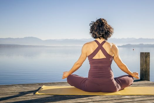 An image of a pretty woman doing yoga at the lake