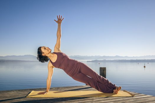 An image of a pretty woman doing yoga at the lake