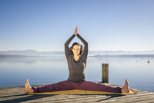 An image of a pretty woman doing yoga at the lake