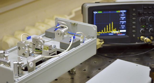 short-pulse laser with
pulse train oscilloscope on the background in Laser Laboratory; focus on laser board