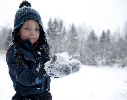 Young boy trying to make a snowball