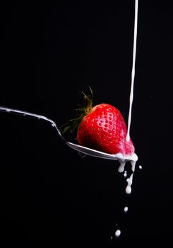 A piece of fruit in a spoon milk dropping