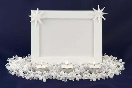 White photo frame decorated with stars. front frame 3 candles. blue background