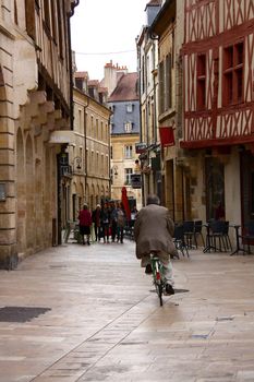 old man biking in center of dijon city at day time