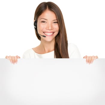 Beautiful Asian woman with a lovely smile wearing a headset and microphone holding a blank white sign in her hands for your advertising or text isolated on white