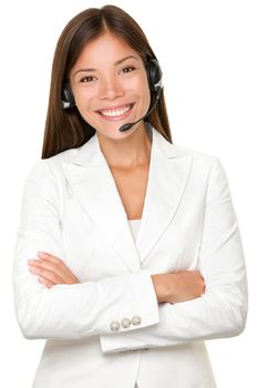 Beautiful cheerful young Asian call operator, receptionist or personal assistant wearing a headset and microphone standing with her arms folded isolated on white