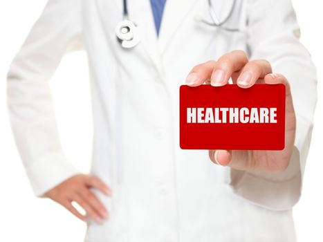 Female doctor holding a red businesscard with white capital lettering HEALTHCARE in her hand, cropped view image with selective focus to the card