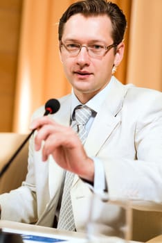 Portrait of a business man holding a microphone and looks ahead