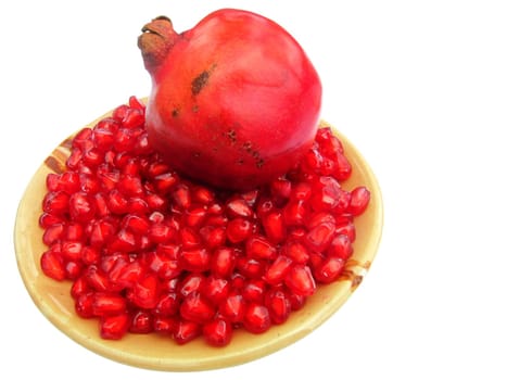 pomegranate (Punica granatum) fruit with seeds on a plate isolated on white