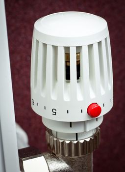 Thermostatic radiator valve with red economy button close-up